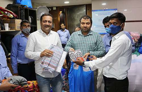 Kiran Gems Directors Dinesh Lakhani and Rajesh Lakhani lend a hand to prepare emergency kits